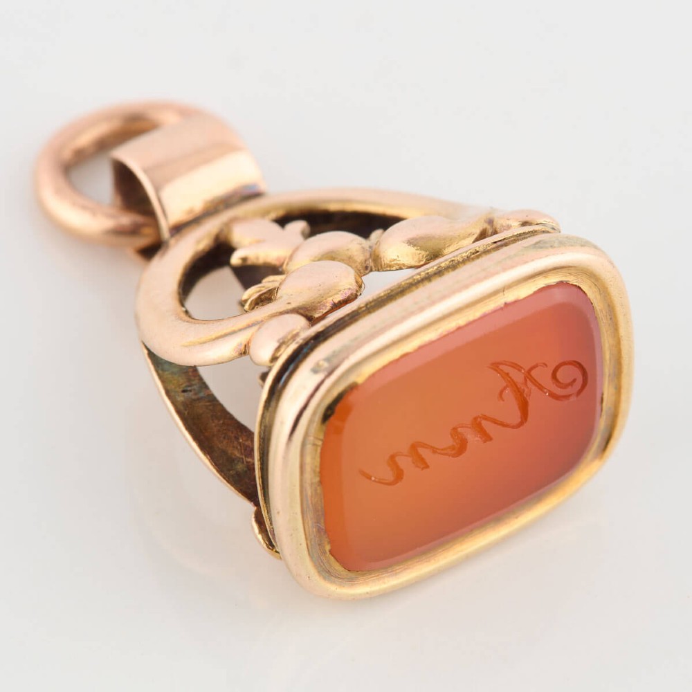 An antique 9ct gold wax seal fob featuring a curved mount and a carnelian base stone. View II