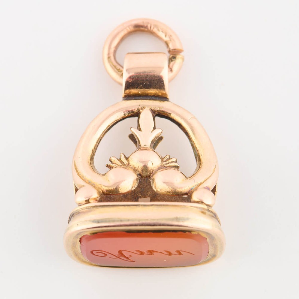 An antique 9ct gold wax seal fob featuring a curved mount and a carnelian base stone. View III