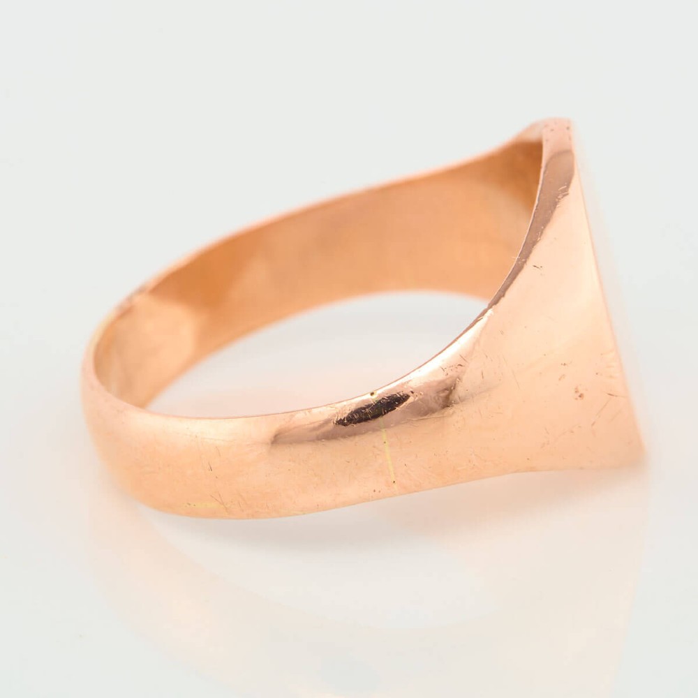 An unengraved 9ct rose gold oval signet ring featuring a polished flat face and thick band. View IV