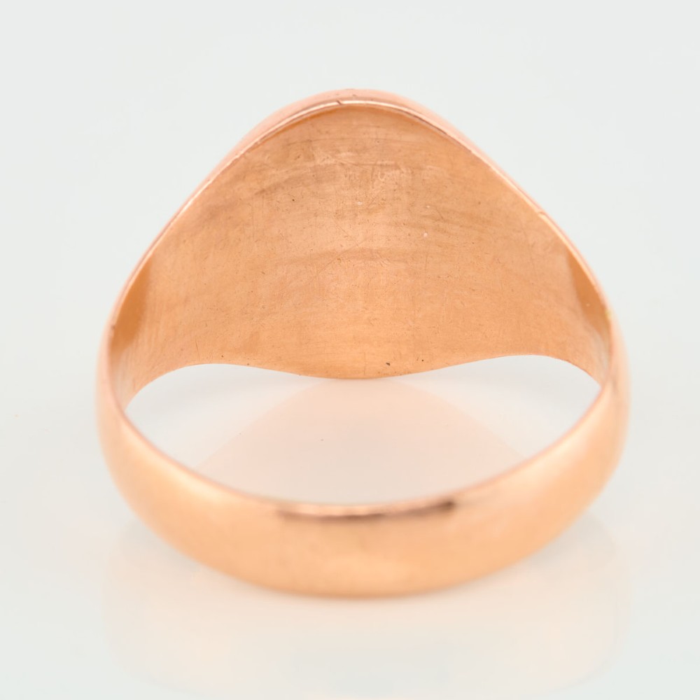 An unengraved 9ct rose gold oval signet ring featuring a polished flat face and thick band. View V