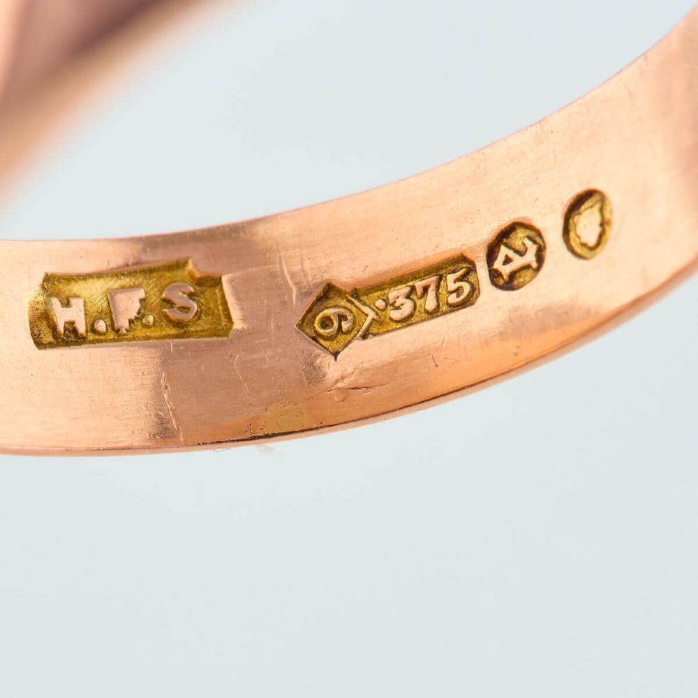An unengraved 9ct rose gold oval signet ring featuring a polished flat face and thick band. View VI