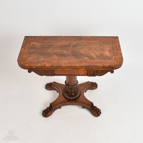 fig 1. A William IV rosewood fold-top card table featuring a rectangular swivel top, carved pedestal, and a quadform base with carved feet.