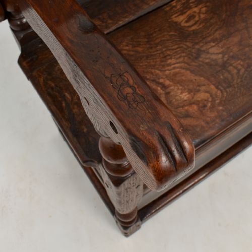 fig 2. An 18th-century dark oak monks bench featuring a convertible tilt-top backrest, turned arm supports, and block legs with perimeter stretchers.