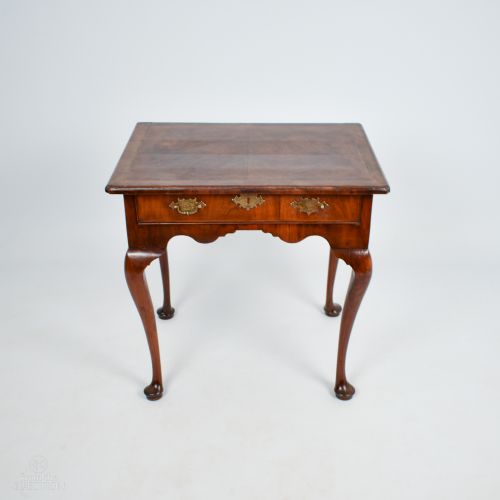 fig 1. A George III walnut side table with cabriole legs, pad feet, a single drawer with brass escutcheons, and a shaped apron.