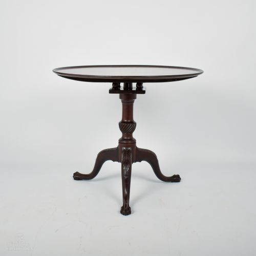 fig 1. A dark mahogany Georgian tilt-top table with a circular surface on a turned pedestal and three carved legs with claw feet.