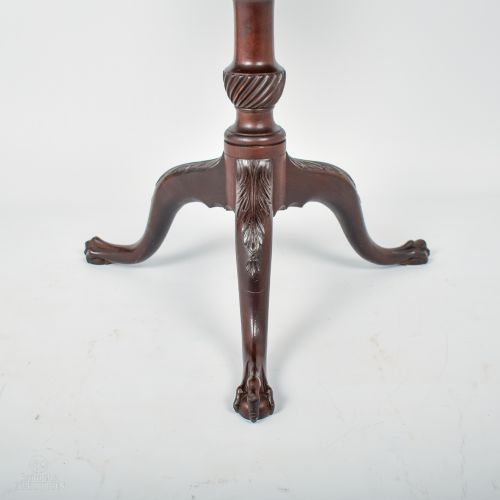 fig 2. A dark mahogany Georgian tilt-top table with a circular surface on a turned pedestal and three carved legs with claw feet.