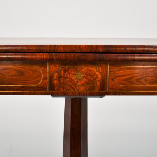 fig 2. A William IV rosewood fold-over tea table featuring a rectangular hinged top, brass inlaid apron, and a central pedestal resting on four carved splayed legs with brass castors.
