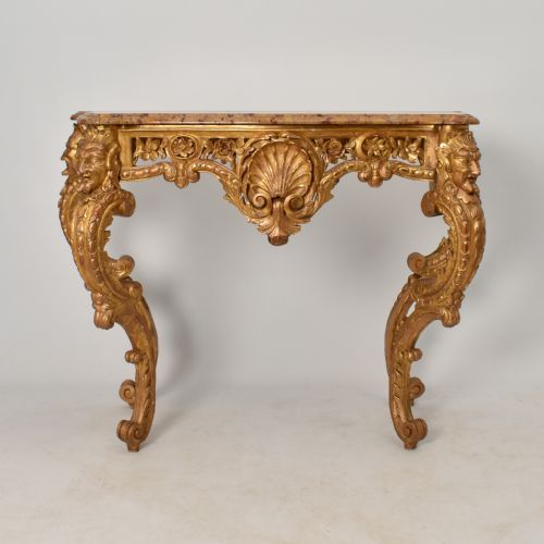 fig 2. A 19th-century giltwood console table featuring carved grotesque masks, central shell carving, and a pink and beige marble top.