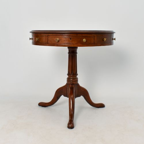 fig 1. A circular Regency mahogany drum table featuring a red leather top, apron drawers with brass knobs, and a turned pedestal on tripod legs.