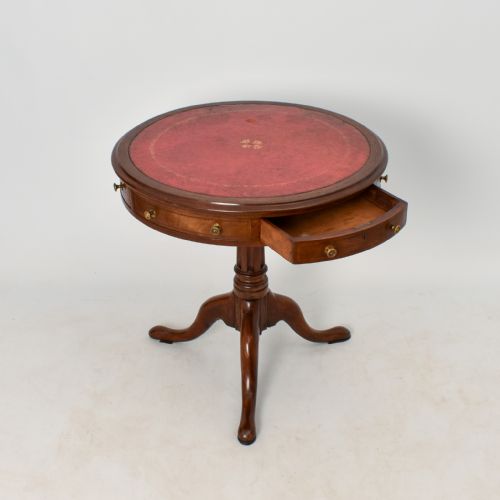 fig 2. A circular Regency mahogany drum table featuring a red leather top, apron drawers with brass knobs, and a turned pedestal on tripod legs.
