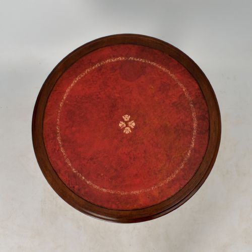 fig 3. A circular Regency mahogany drum table featuring a red leather top, apron drawers with brass knobs, and a turned pedestal on tripod legs.