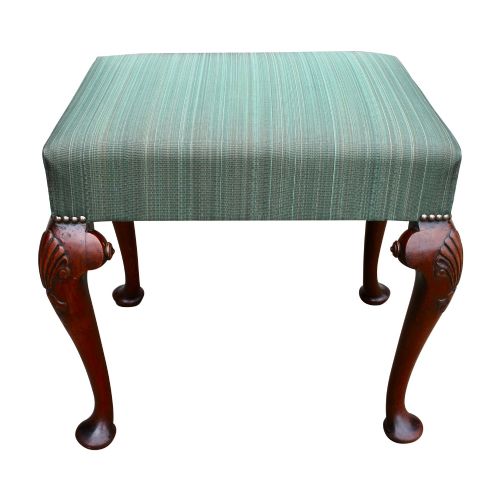 fig 1. A rectangular upholstered stool featuring green striped fabric, brass tack trimming, and four carved solid walnut cabriole legs with shell motifs on the knees.