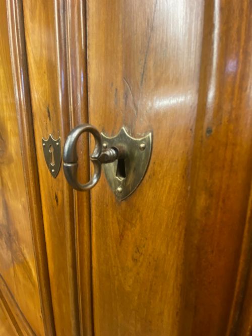 fig 2. A two-part French solid cherry wood housekeepers cupboard featuring double fielded panel doors, twin drawers, and brass escutcheons.