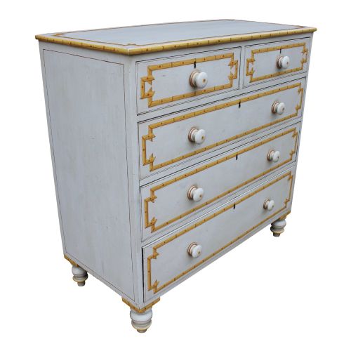 fig 2. A nineteenth-century painted chest of drawers featuring decorative yellow faux bamboo borders across four drawer fronts with turned handles and bun feet.