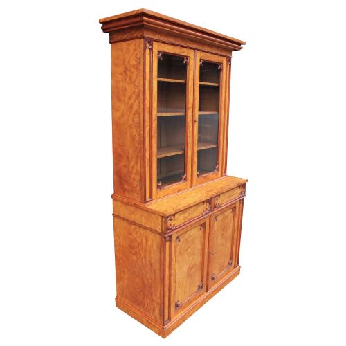 fig 2. A 19th-century Gothic Revival two-part satinwood bookcase featuring a glazed upper cabinet with tracery trim above a solid door base.