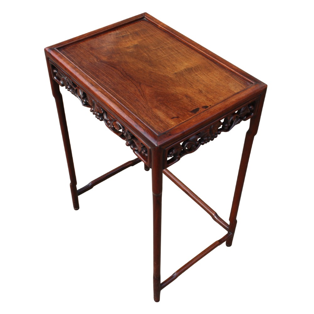 A graduated set of four dark brown solid rosewood Chinese nesting tables featuring intricately carved aprons and slender legs. View III