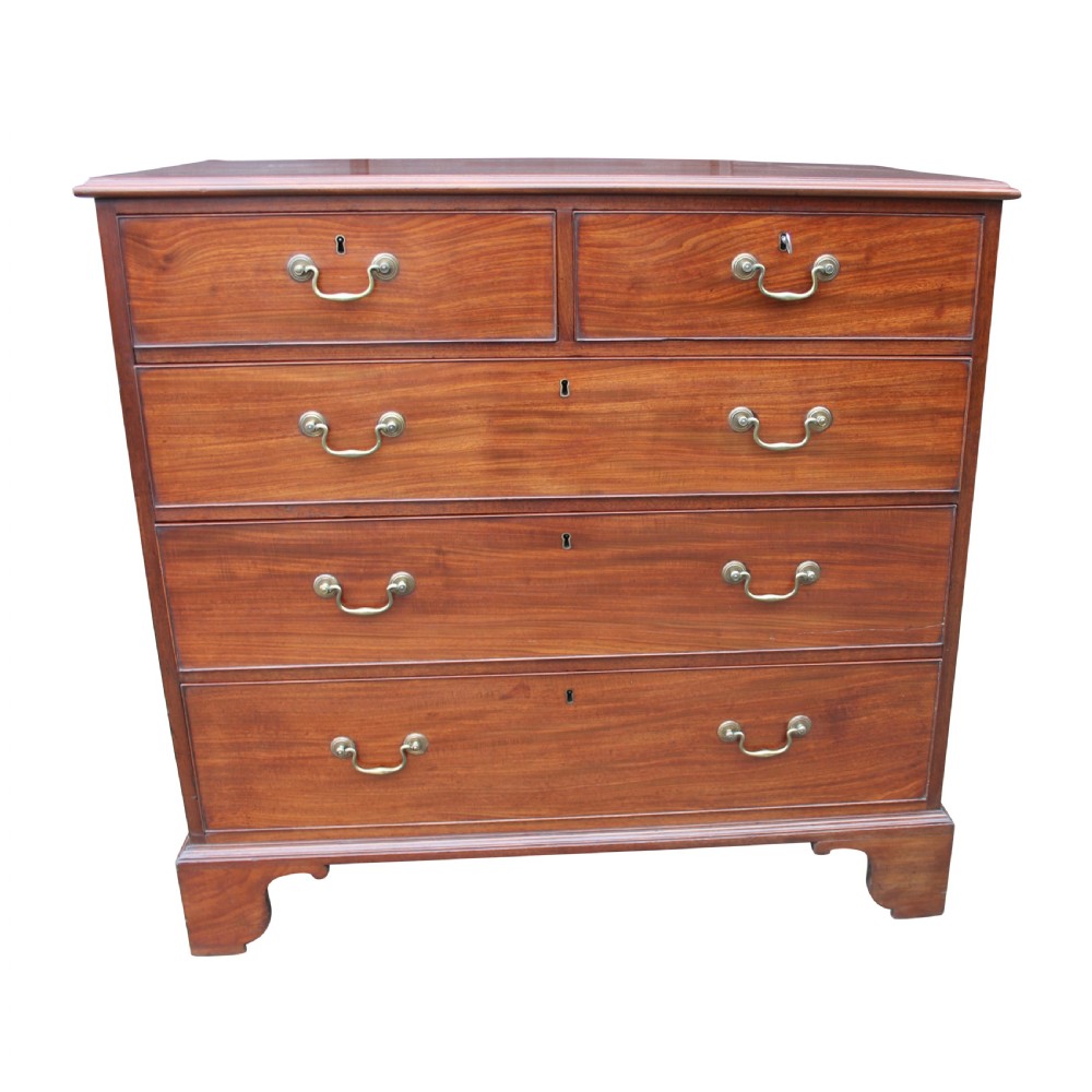 A freestanding Georgian solid mahogany chest of drawers featuring two upper small drawers over three graduating long drawers fitted with brass swan neck handles.