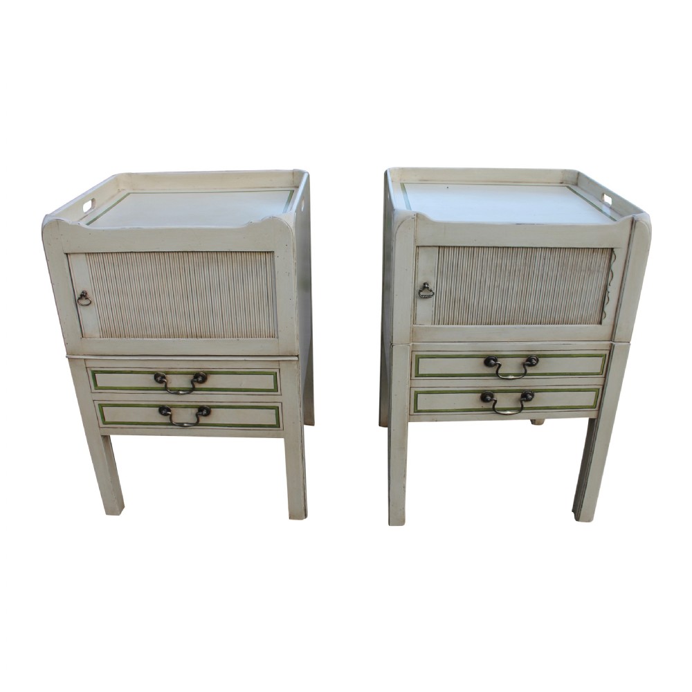 A matched pair of cream-painted Georgian bedside cupboards featuring tambour front doors above two small drawers with green painted trim and brass pulls.