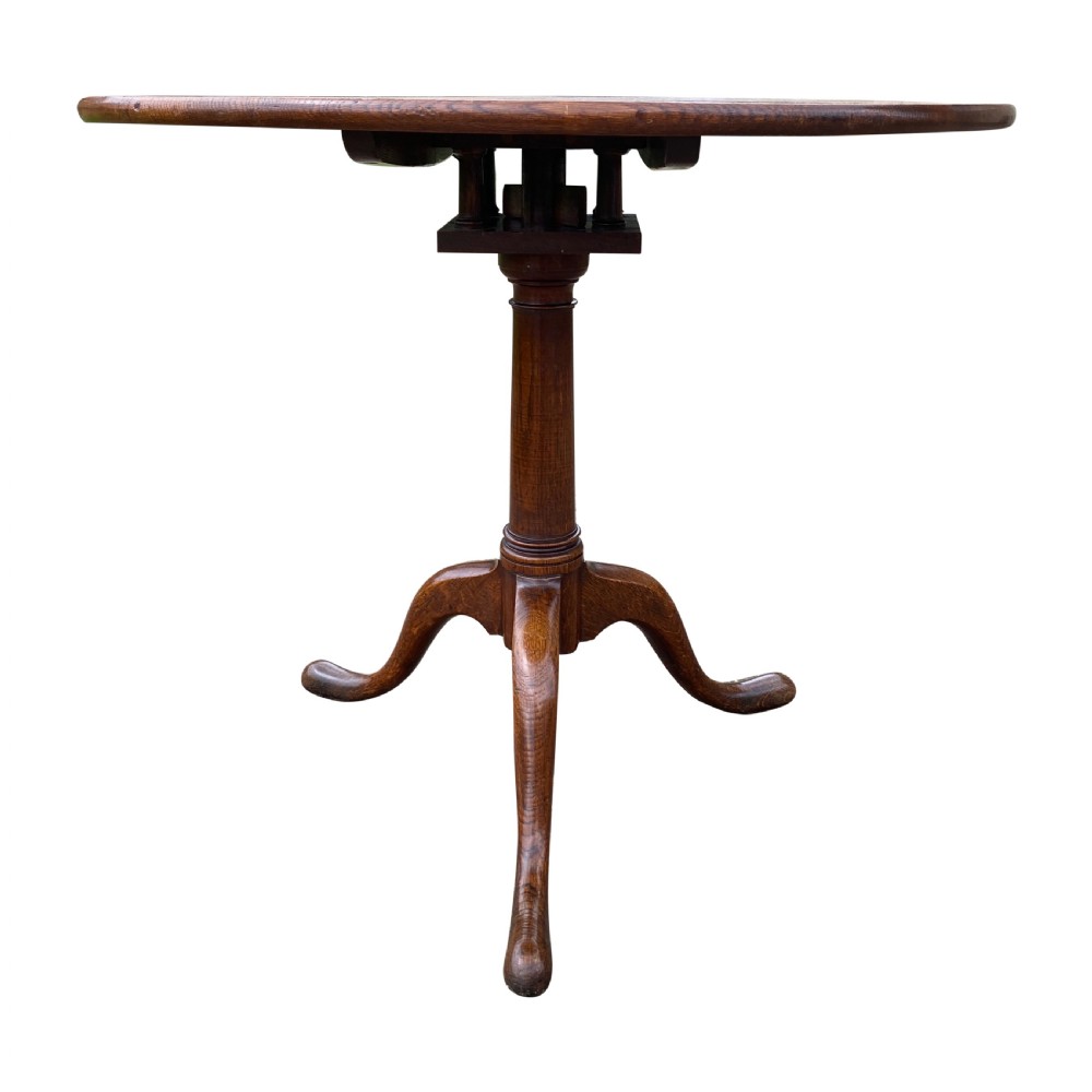 An antique Georgian circular oak tripod table with a central pillar and three curving cabriole legs. View II