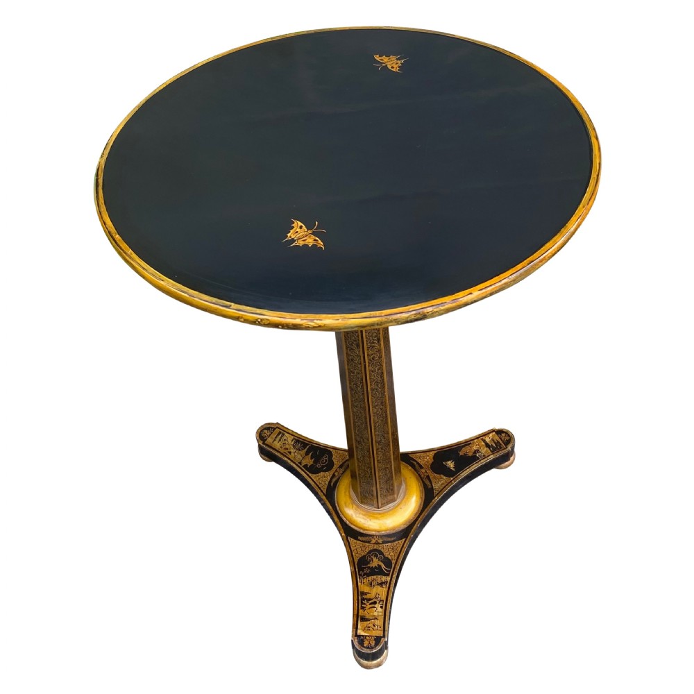 An antique circular black lacquer lamp table featuring intricate hand-painted gold chinoiserie motifs on a single pedestal with three splayed feet. View II