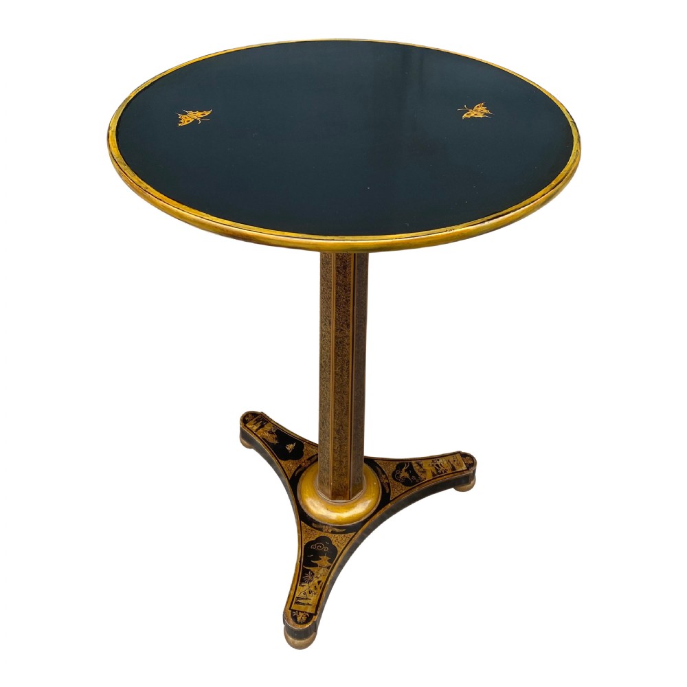 An antique circular black lacquer lamp table featuring intricate hand-painted gold chinoiserie motifs on a single pedestal with three splayed feet. View III