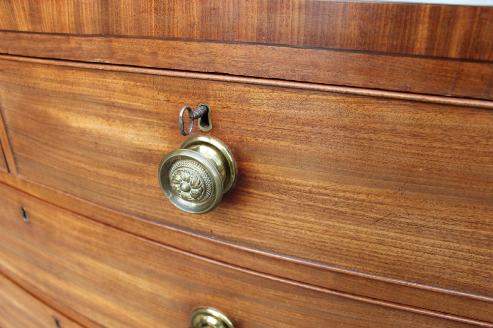 An early 19th-century mahogany bow fronted chest of drawers featuring two short upper drawers above three graduated long drawers with circular brass pulls. View III