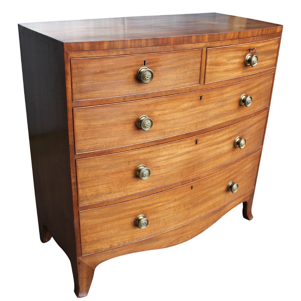 An early 19th-century mahogany bow fronted chest of drawers featuring two short upper drawers above three graduated long drawers with circular brass pulls. View V