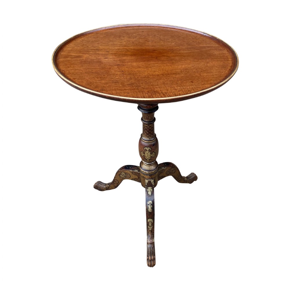 An Anglo-Indian tripod side table featuring a circular tray top supported by a detailed lacquered stem and three splayed legs.