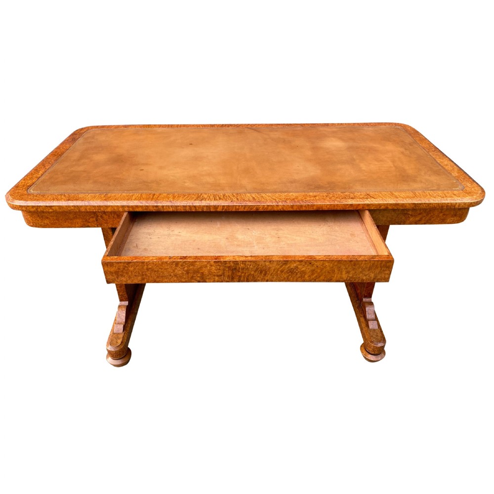 A nineteenth-century rectangular amboyna writing table featuring a brown leather inset top and dual trestle supports. View V