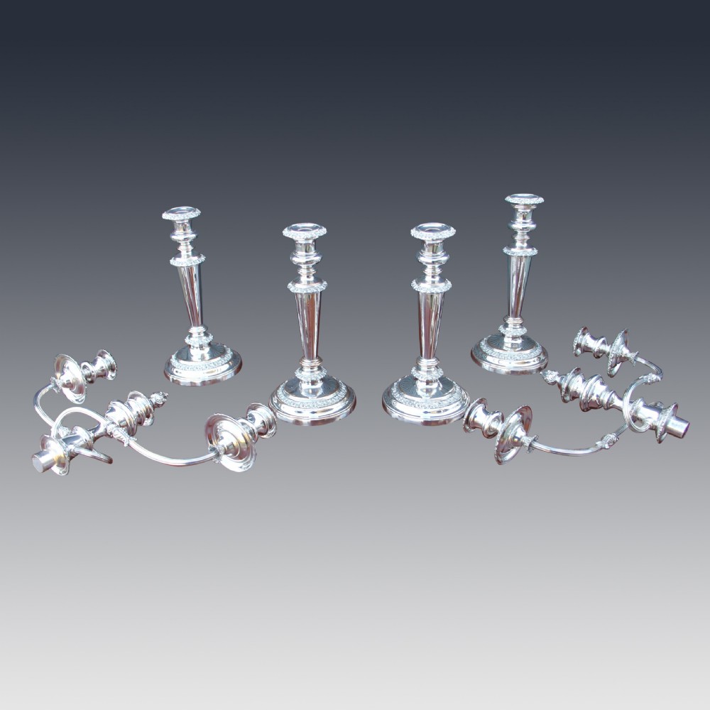 A set of four matching nineteenth-century Sheffield plate candelabras and candlesticks featuring polished silver finishes and classical tiered bases. View III