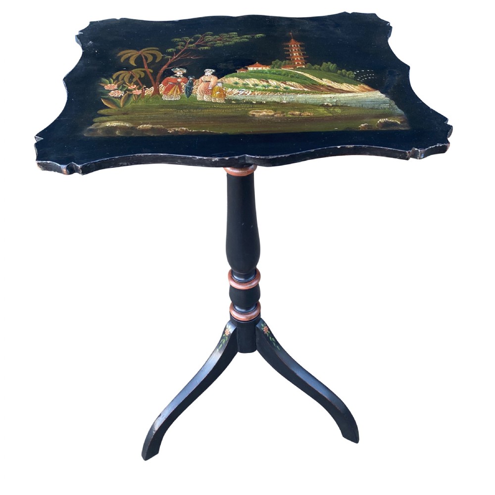 A 19th-century black lacquered tripod side table with a shaped rim hand-painted with an East Asian pagoda landscape scene, supported by a turned column and three splayed legs.