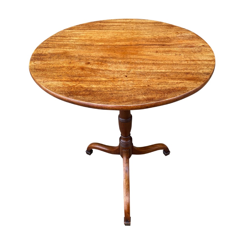 An overhead view of a round George III solid mahogany tilt-top occasional table on a tripod base.