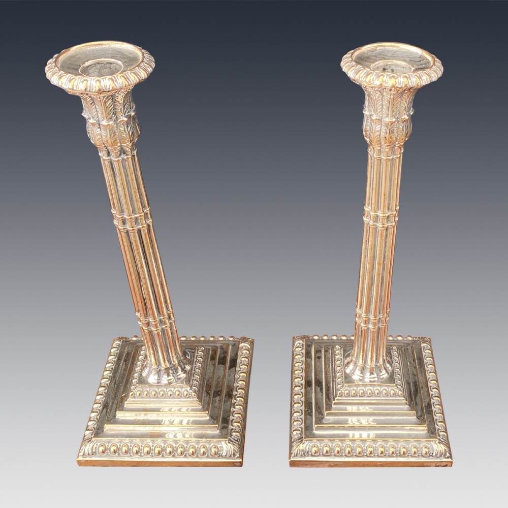 A pair of Georgian Old Sheffield Plate silver candlesticks featuring fluted columnar shafts, acanthus capitals, and stepped square bases with beaded edging. View II