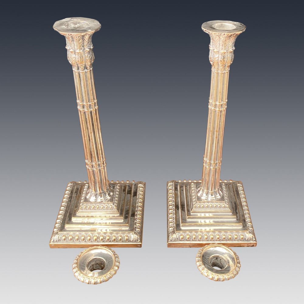 A pair of Georgian Old Sheffield Plate silver candlesticks featuring fluted columnar shafts, acanthus capitals, and stepped square bases with beaded edging. View III