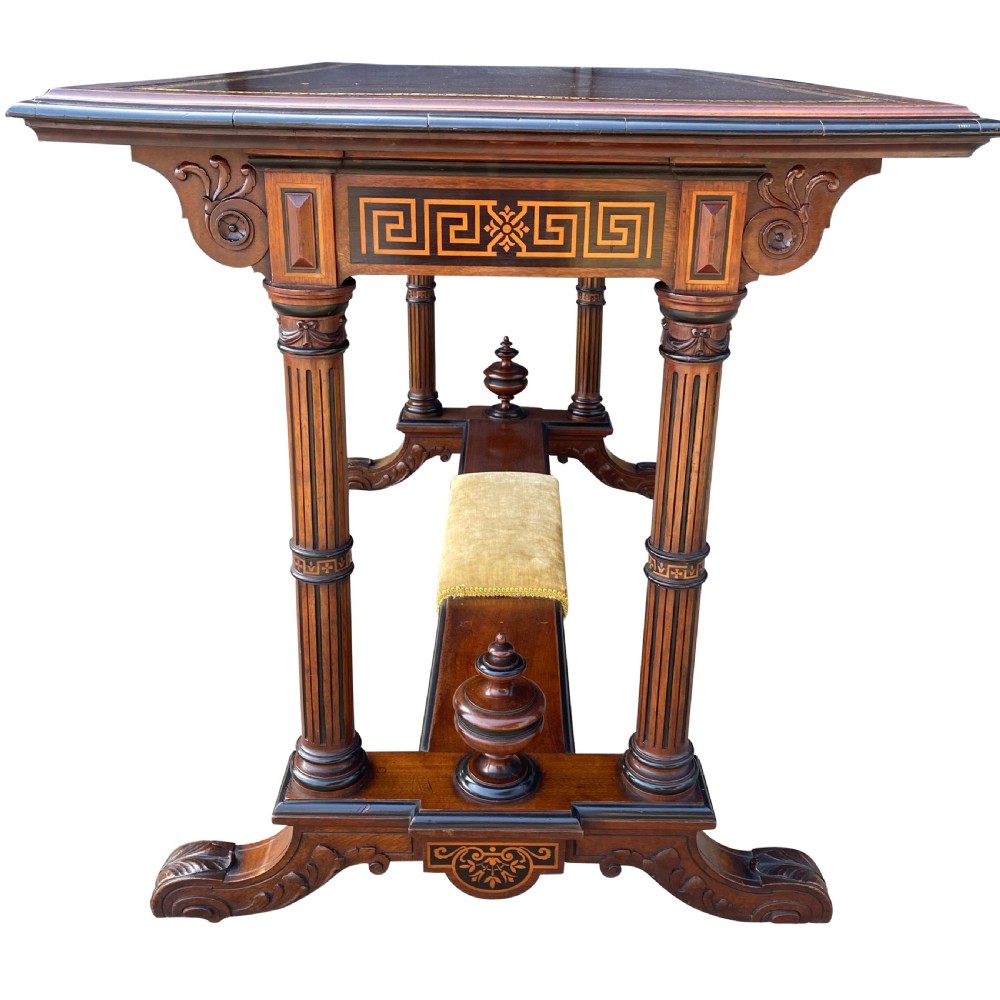 Late nineteenth-century mahogany writing table featuring a dark brown leather inset top with gilded tooling, fluted legs, and a central velvet-padded footrest on a low stretcher. View V