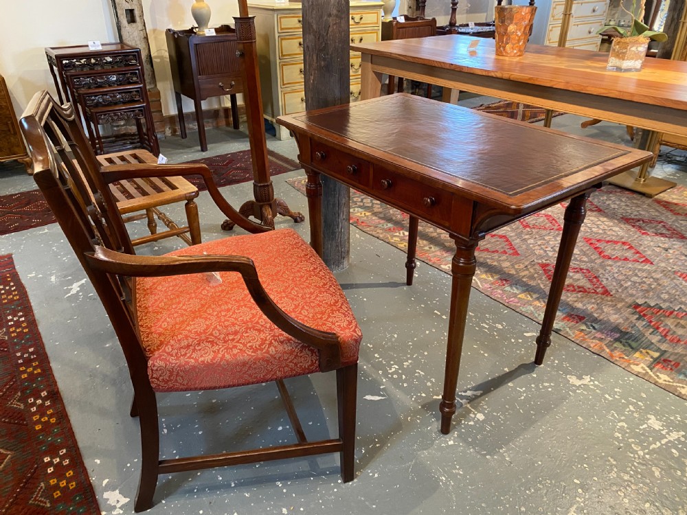 Late nineteenth-century mahogany writing table featuring a dark brown leather inset top with gilded tooling, fluted legs, and a central velvet-padded footrest on a low stretcher. View VIII