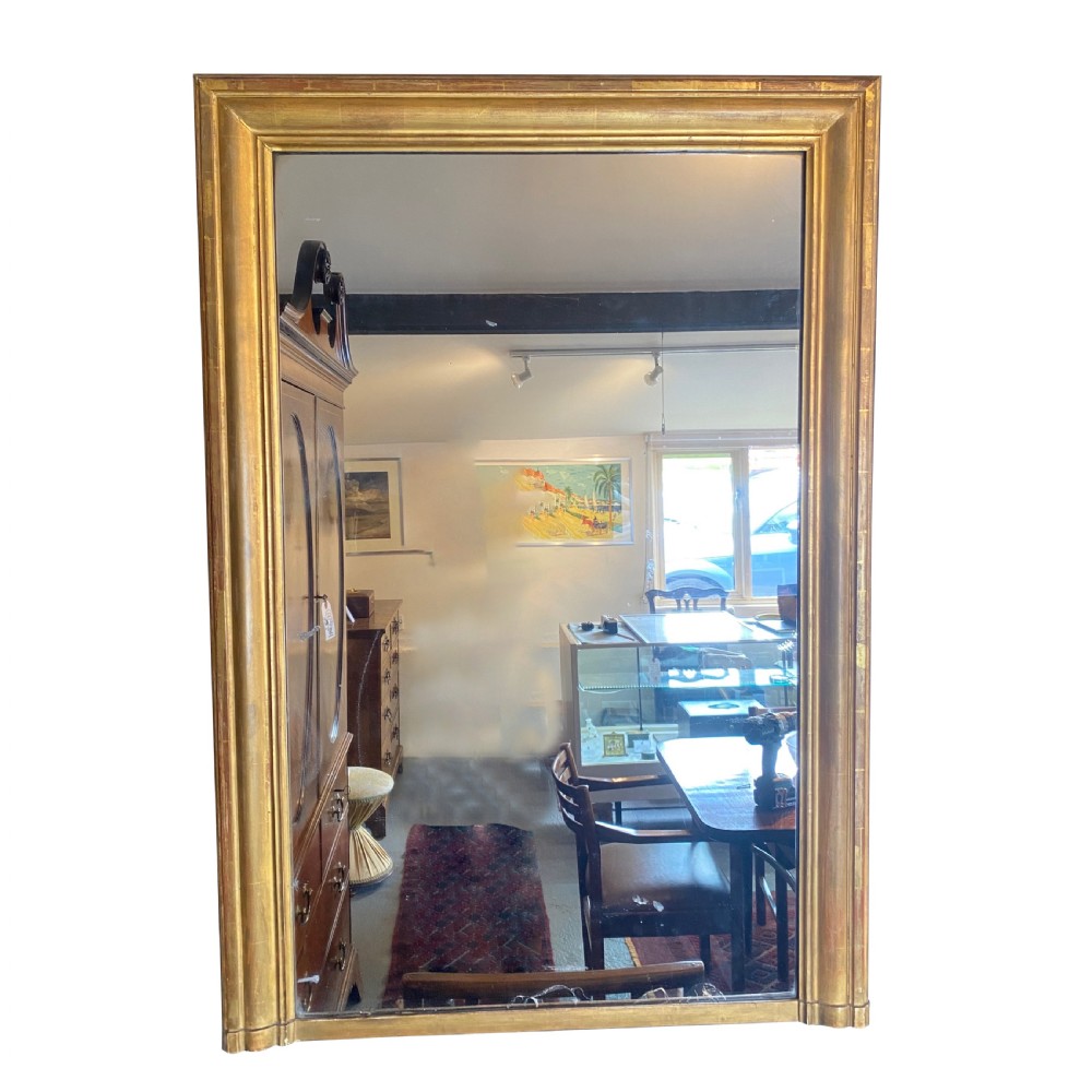 A large rectangular early 19th-century wall mirror featuring a moulded gold leaf giltwood frame and clear mirror plate.