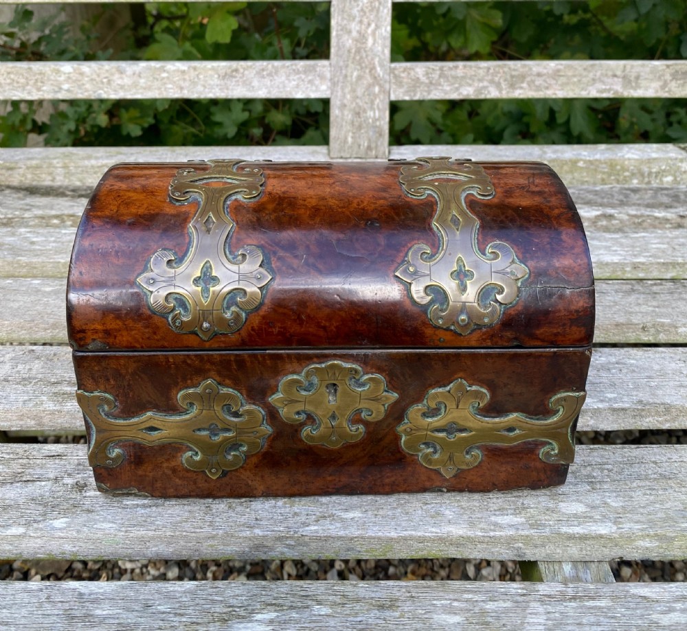 A 19th-century domed amboyna burr wood box featuring decorative brass strapwork mounts and corner fittings. View II