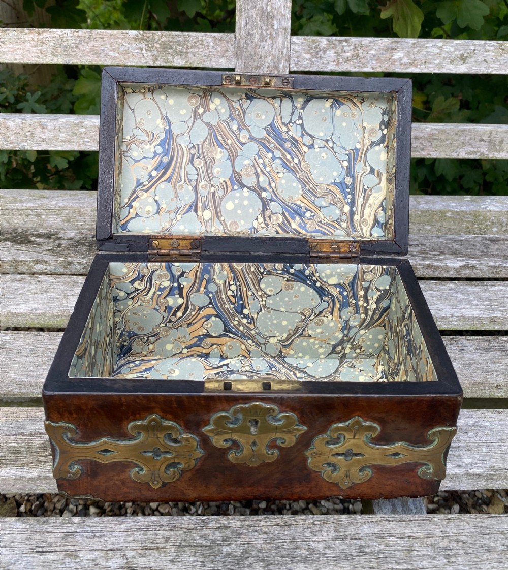 A 19th-century domed amboyna burr wood box featuring decorative brass strapwork mounts and corner fittings. View III