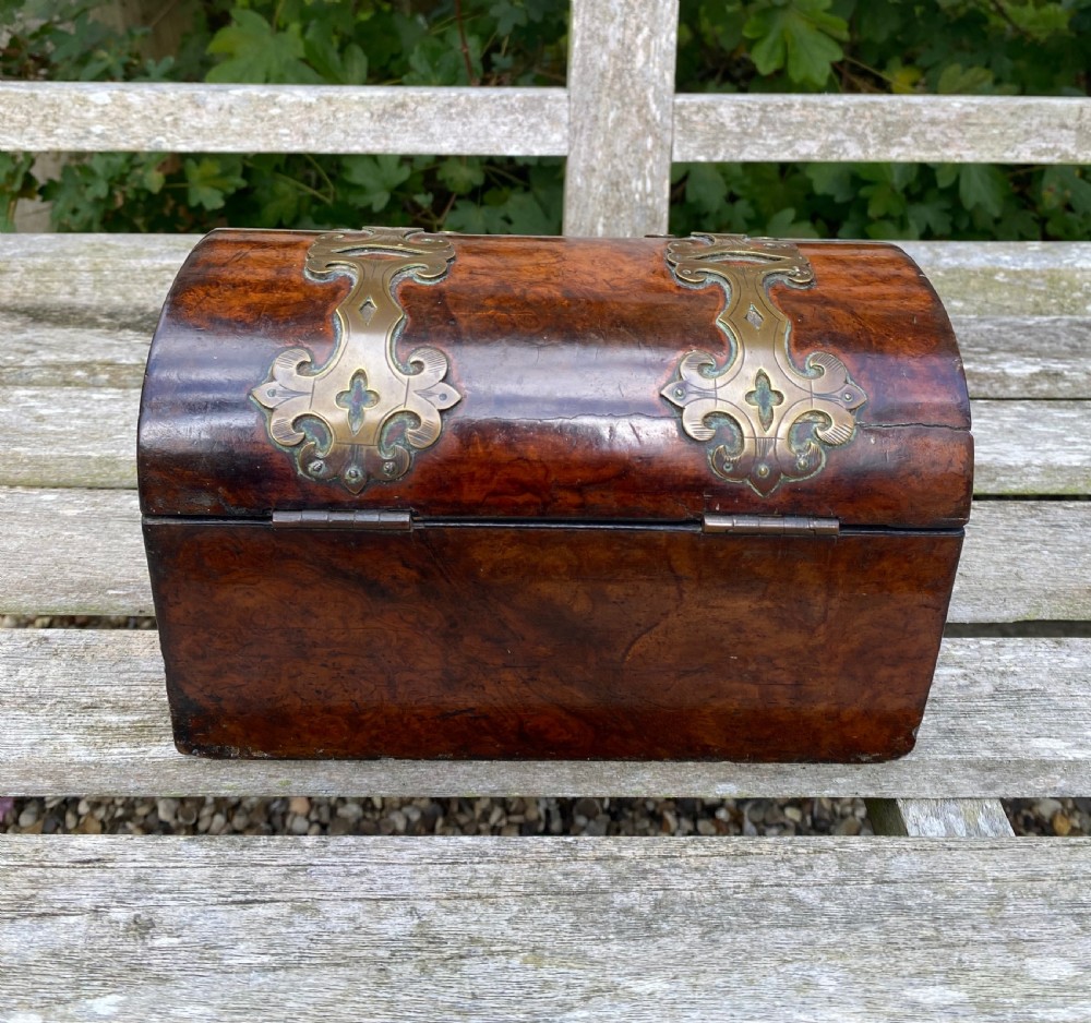 A 19th-century domed amboyna burr wood box featuring decorative brass strapwork mounts and corner fittings. View VII