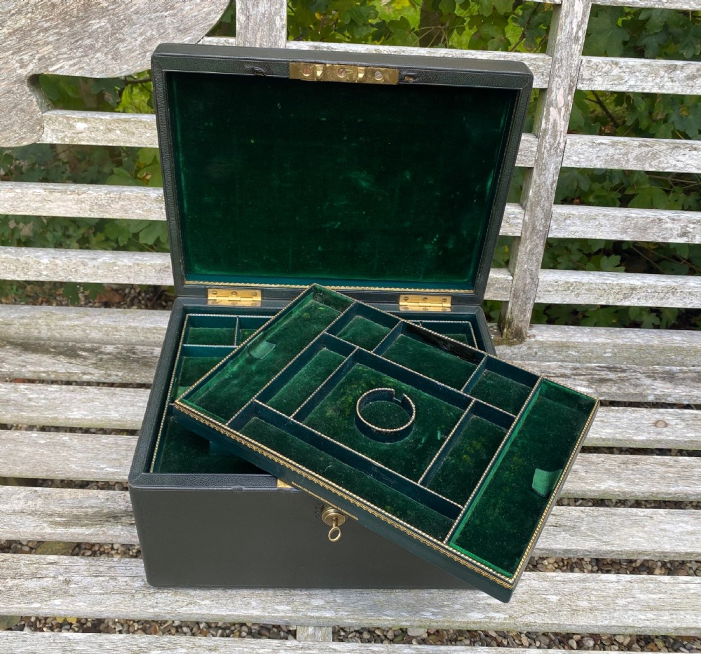 An open 19th-century dark leather jewellery box revealing a green velvet compartmentalised tray and brass lock mechanism. View IV