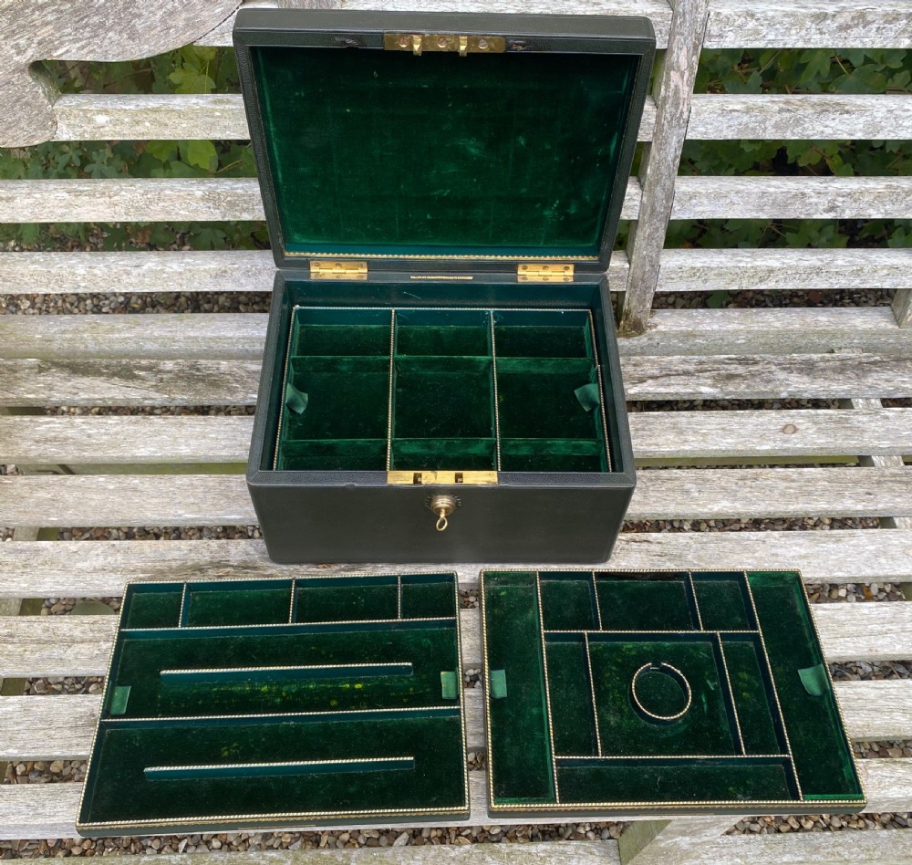 An open 19th-century dark leather jewellery box revealing a green velvet compartmentalised tray and brass lock mechanism. View VI