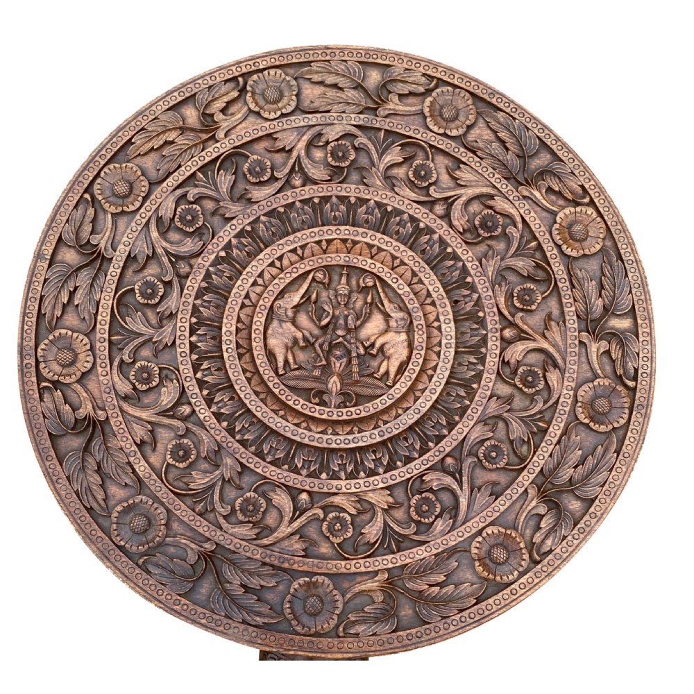 A circular hand-carved rosewood side table with a floral relief surface and three legs shaped as detailed elephant heads with downturned trunks. View III