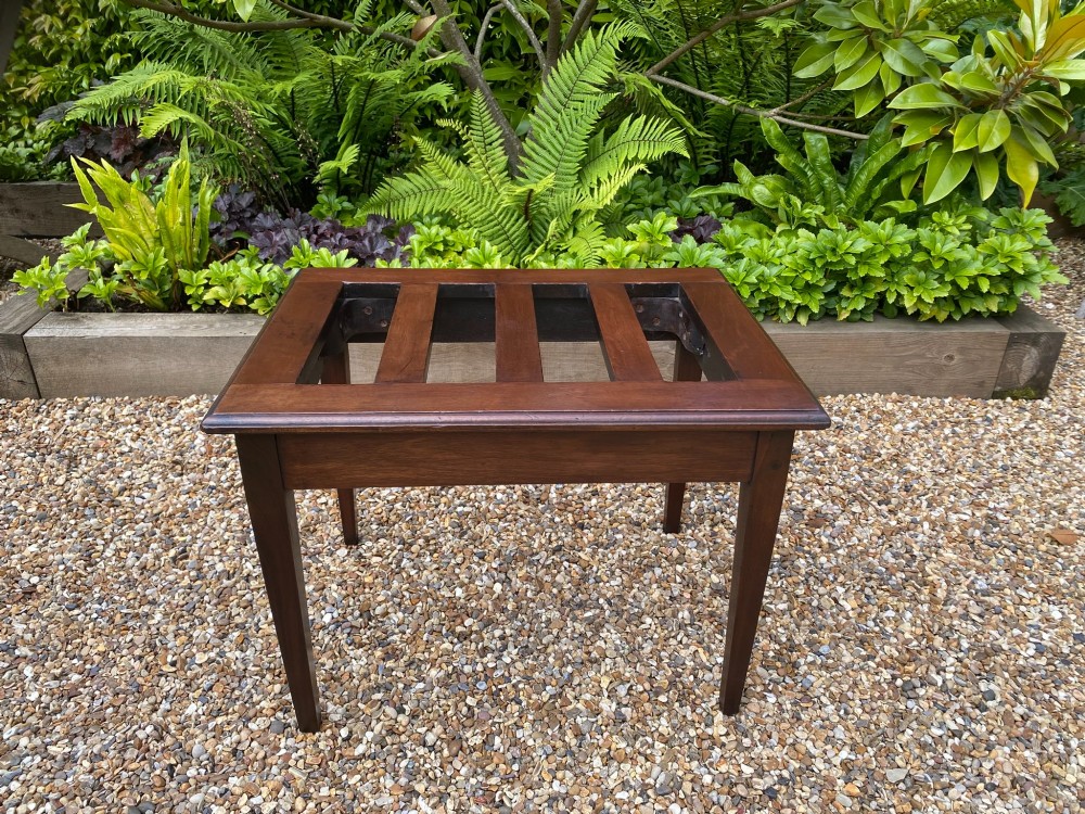A dark mahogany slatted luggage stand featuring four central slats and four straight tapered square legs.