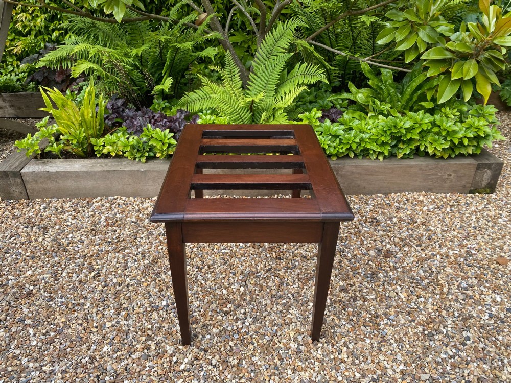A dark mahogany slatted luggage stand featuring four central slats and four straight tapered square legs. View IV