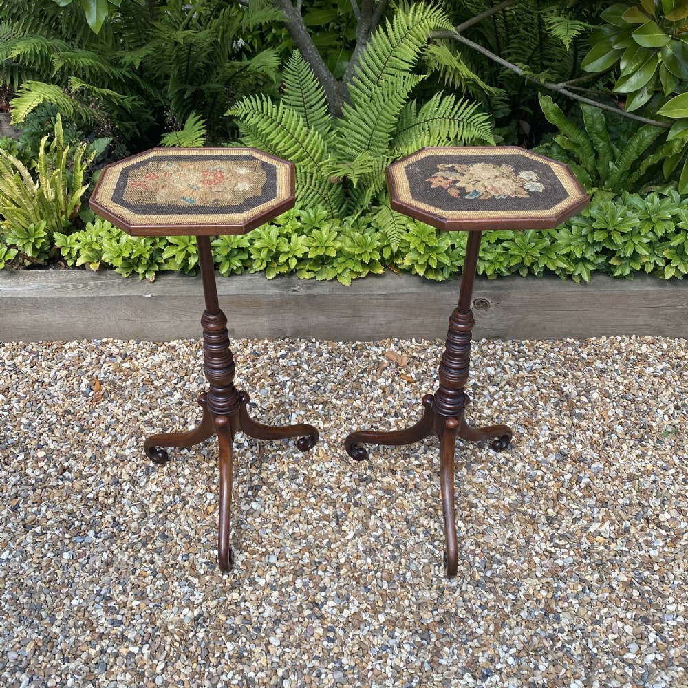 A pair of antique Georgian mahogany wine tables with octagonal needlework tops, ring-turned stems, and tripod bases with scroll feet.