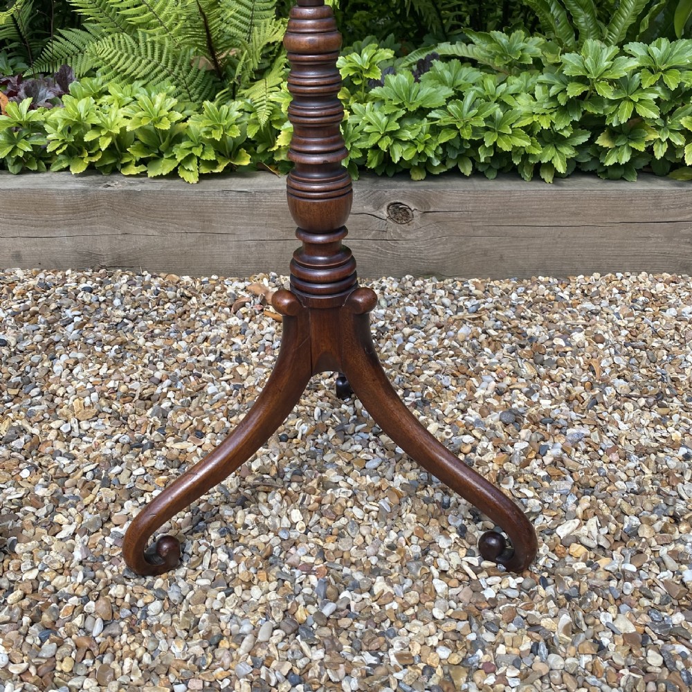 A pair of antique Georgian mahogany wine tables with octagonal needlework tops, ring-turned stems, and tripod bases with scroll feet. View V