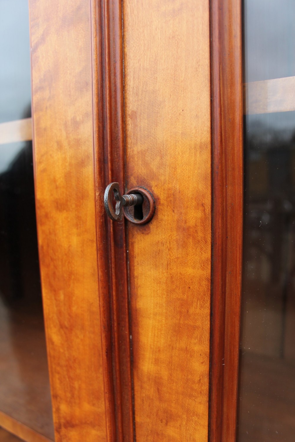 A 19th century Gothic Revival two-part satinwood bookcase featuring glazed upper doors with Gothic tracery and a matching lower cupboard section. View IV