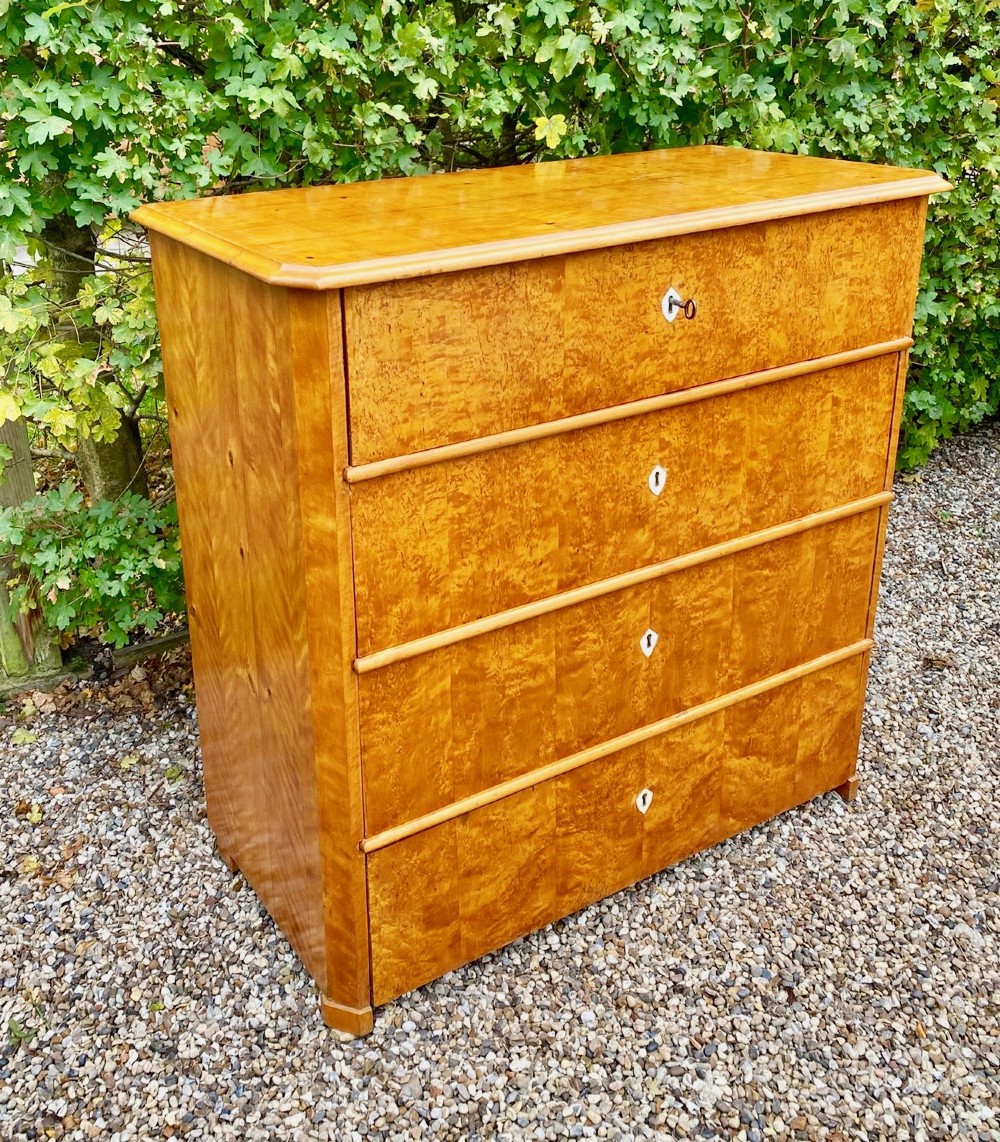 A mid-19th-century Swedish satin birch chest featuring four straight drawers with central keyhole escutcheons. View II