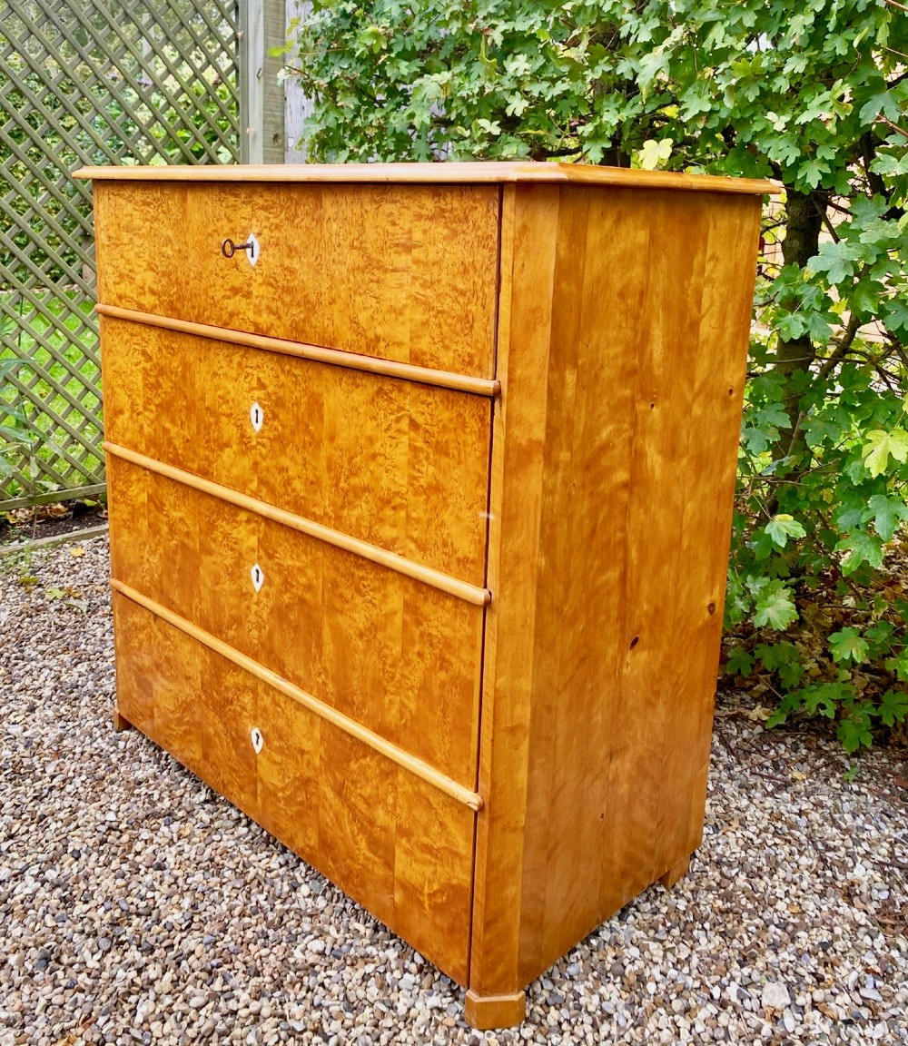 A mid-19th-century Swedish satin birch chest featuring four straight drawers with central keyhole escutcheons. View III